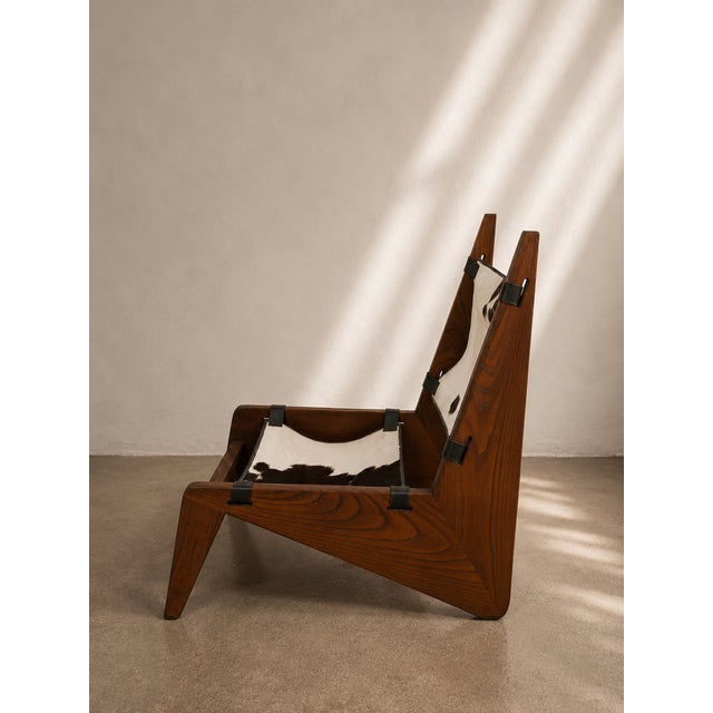 Handcrafted lounge chair by OSSO Furniture Studio, featuring a sculptural solid wood frame paired with a natural cowhide...