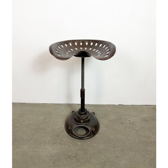 Vintage industrial height adjustable swivel chair from 1950s. An old tractor seat mounted on an iron construction....