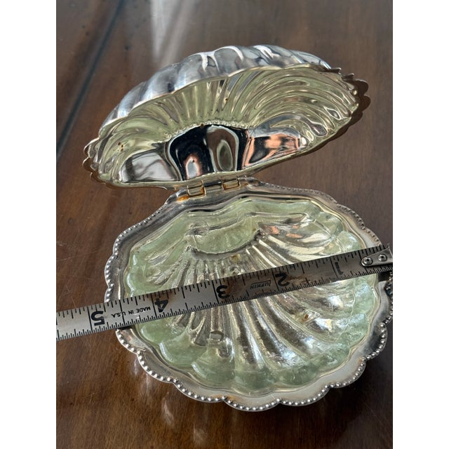 A beautifully sculptural hinged shell dish that feels more like a decorative object than a simple catchall. Crafted in...