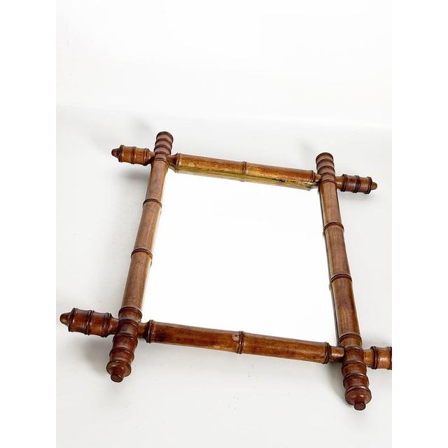 Decorative French wooden wall mirror dating from the 1930s, featuring an elegant architectural frame inspired by turned...