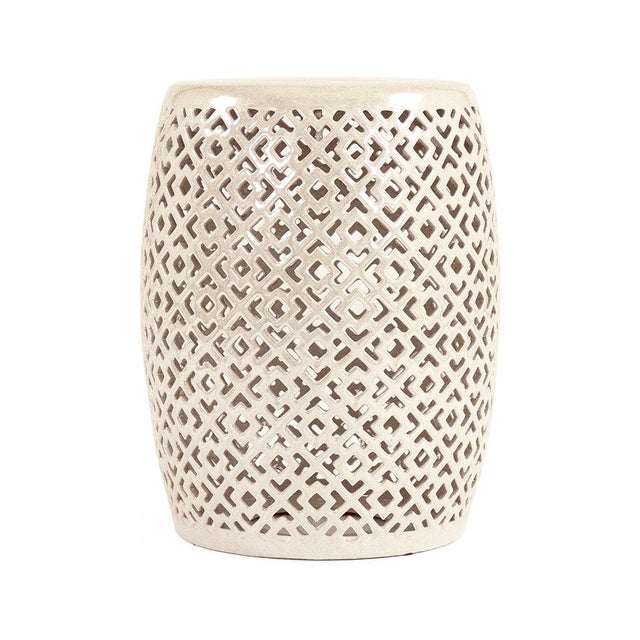 The Lorin Garden Stool is a ceramic garden stool with a barrel form and a geometric diamond pierced pattern in a high-...
