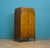 Art Deco walnut tallboy with figured veneer and shaped legs. Single top drawer. Double doors open to two internal drawers...