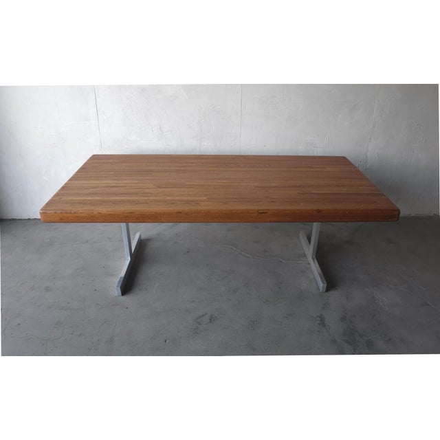 This is a striking vintage dining table featuring a substantial solid oak top paired with a sleek aluminum trestle base....