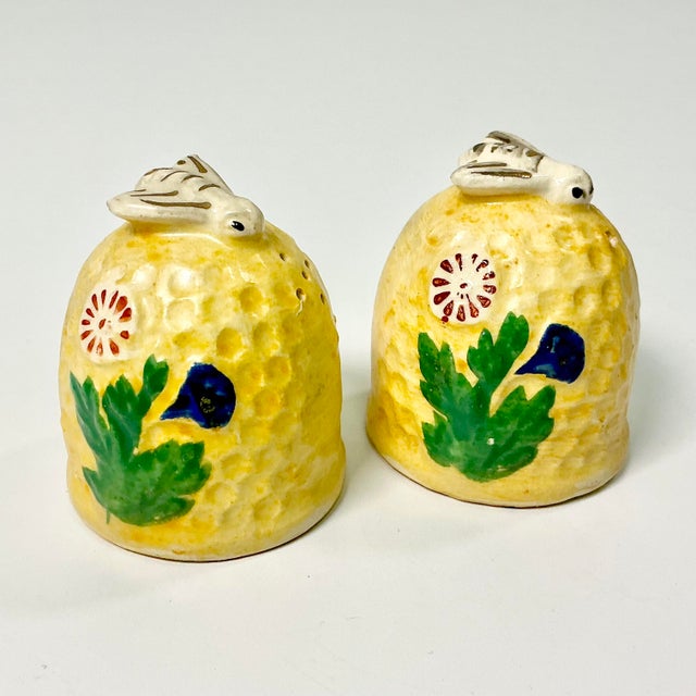 These vintage salt & pepper shakers are whimsical and adorable. They feature a sunny yellow honeycomb graced by two bees...