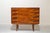 Four-drawer cabinet on a single level, supported by four legs. Each drawer has two rectangular wooden handles, and the...
