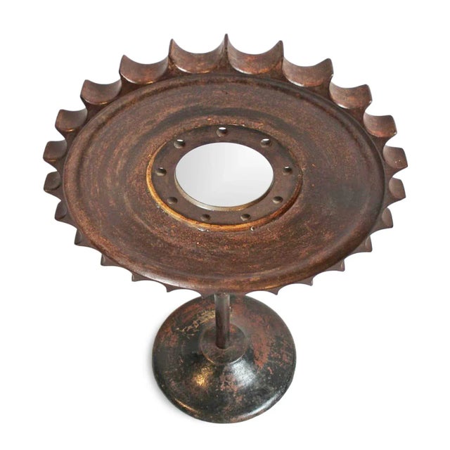 Unique vintage industrial heavy iron sun shaped gear repurposed into a mirror. Raised up on distressed iron stand....