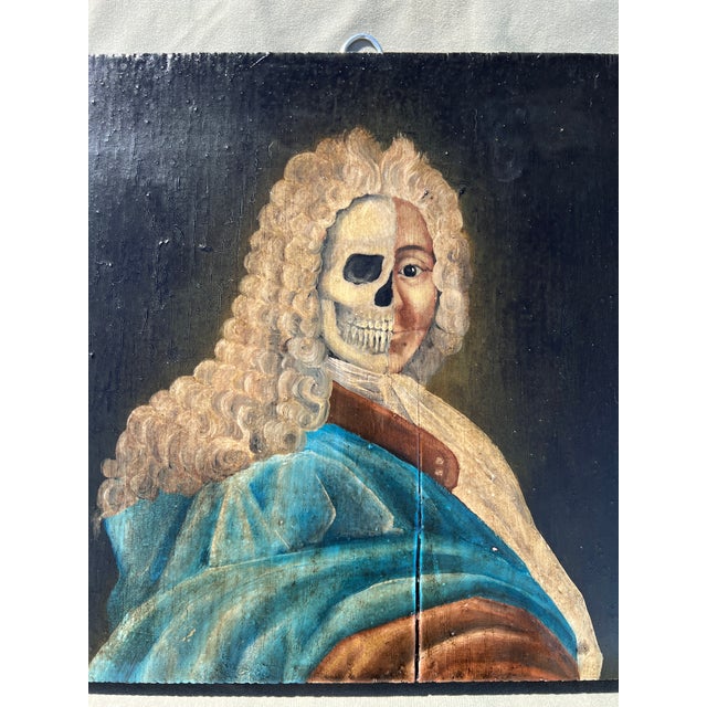 Oil on wood baroque style Memento Mori painting of noble frenchman in blue coat, dual skull face and powdered wig. The...