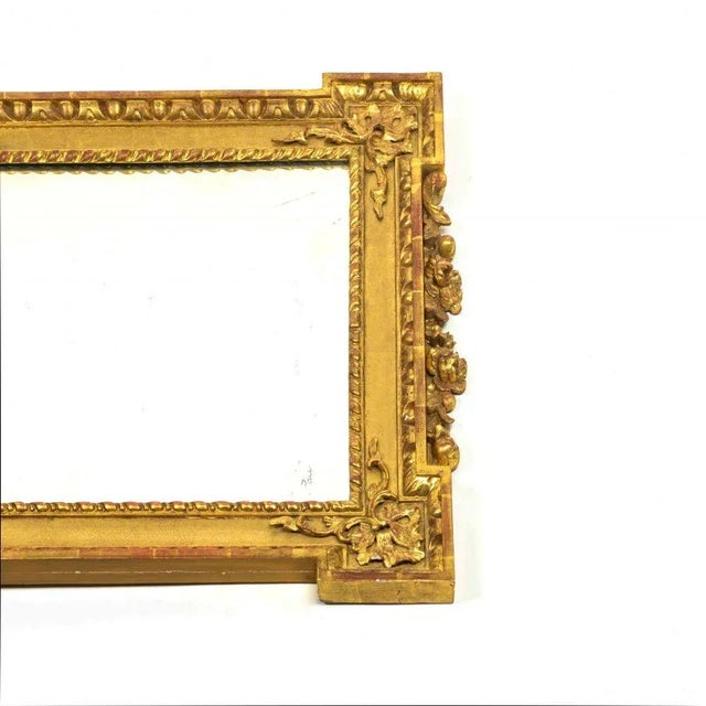 With rectangular mirror plate within a conforming surround with outset corners and enriched with gadrooned and egg and...