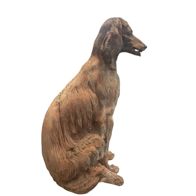 This monumental terracotta sculpture captures the elegant silhouette of a seated Setter (likely an English or Irish...