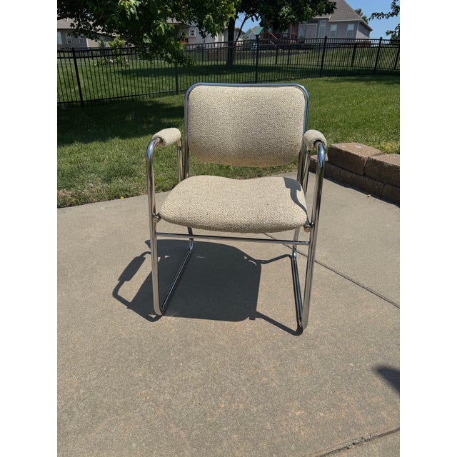Striking vintage chair featuring a polished chrome tubular frame and original neutral textured upholstery. This piece...