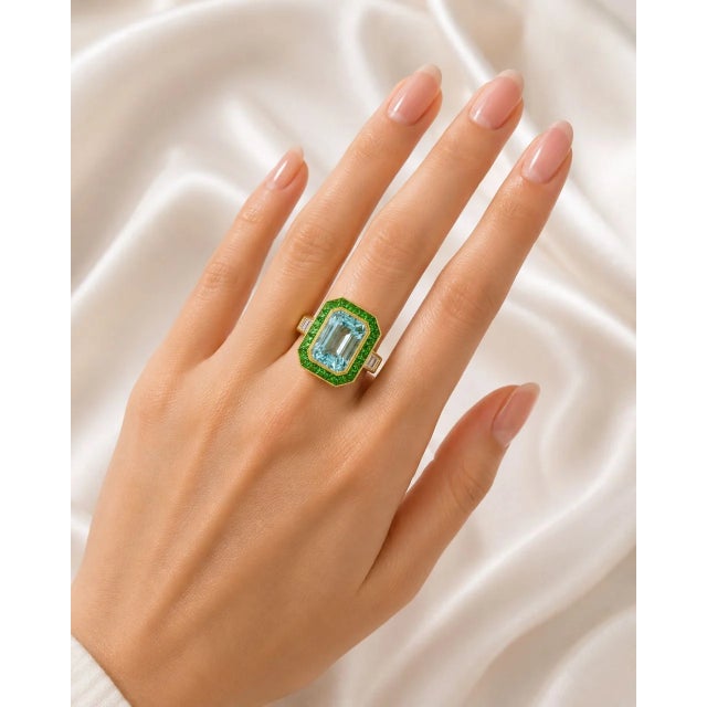 Elegant 18K yellow gold mosaic statement ring featuring a natural emerald-cut aquamarine centerpiece weighing 4.24 carats....
