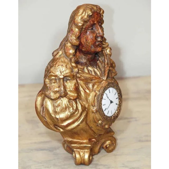 A finely carved, painted and gilded bust on a scrolled base, the shoulders of the gentleman's robes carved in forms of...