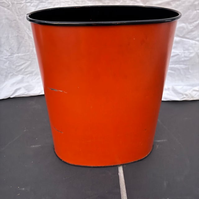 Vintage metal trashcan with a pair of black birds and branches on a red background. Enameled red background. Unsure of the...