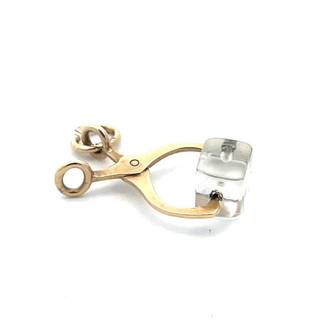 A charming vintage ice tongs pendant crafted in solid 14K yellow gold, featuring a clear rock crystal “ice cube” detail....