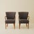 Pair of Danish armchairs dating from the 1940s–50s, each with an oak frame, sculpted armrests, and upholstered seat and...