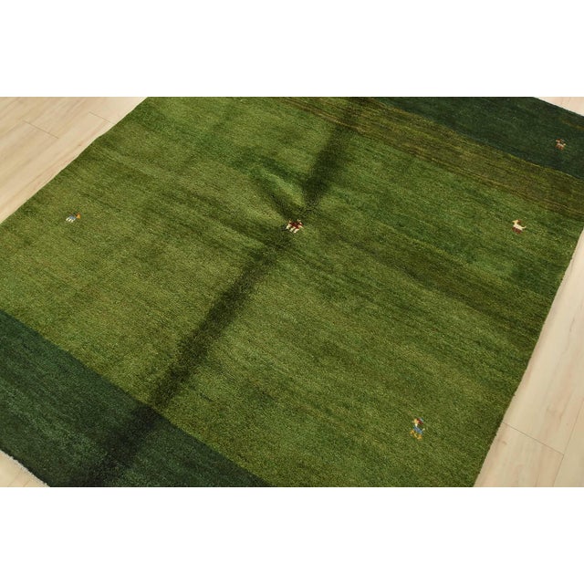 An authentic vintage tribal Gabbeh rug hand-knotted with fine wool and natural dyes. This plush nomadic rug features...