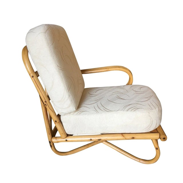 Rare "Triple Triangle" arm rattan lounge chair featuring arch looped base and the unique open-air single arm design....