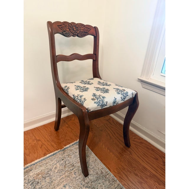 Beautiful vintage antique chairs featuring an elegant Duncan Phyfe-inspired silhouette and intricate carved rose details....