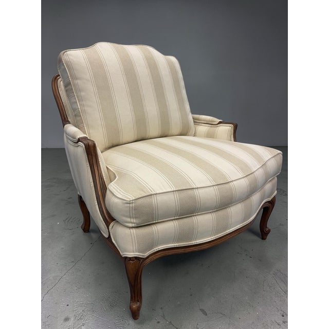 Classic Ethan Allen bergère lounge chair with matching ottoman, featuring a carved hardwood frame with graceful cabriole...