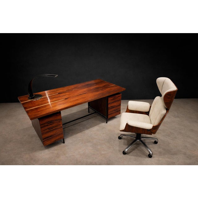 A structurally confident Brazilian Modern desk attributed to Geraldo de Barros, executed in solid rosewood and veneer with...