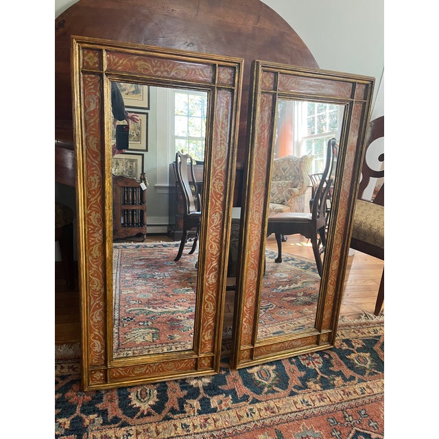 Pair of elegant, elongated, decorative mirrors, circa 1900. Lovely pale orange color and gold leaf.