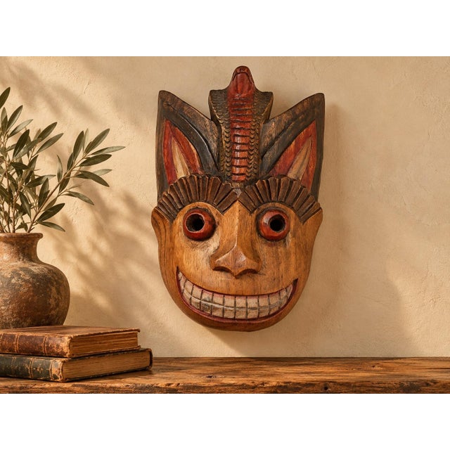 A remarkable vintage Thai folk-art wall mask, distinguished by a boldly expressive primate-like face crowned by a...