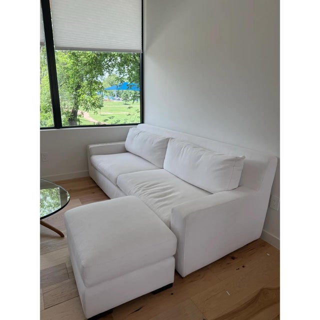 A clean-lined Modena Track Arm sofa and matching ottoman from Restoration Hardware's flagship modern collection,...