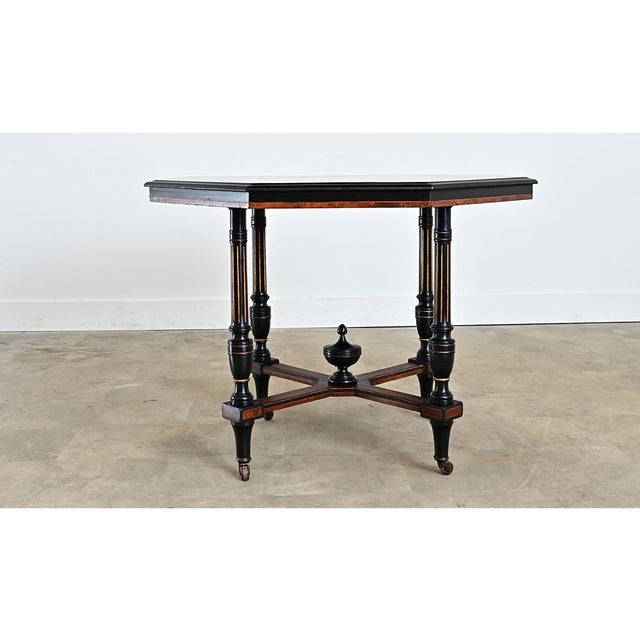 Dutch, 19th century Empire-style octagonal center table that features ebonized detail around burled maple surface. The...