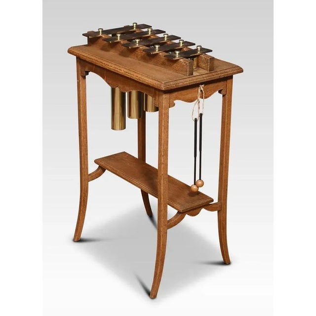 Oak-cased glockenspiel, the solid oak frame supporting five brass keys with tubular brass cylinders below. All raised up...
