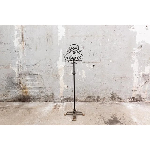 Lectern to support a book or poster made of forged iron. Curved iron structure for the lectern on a single shaft that...