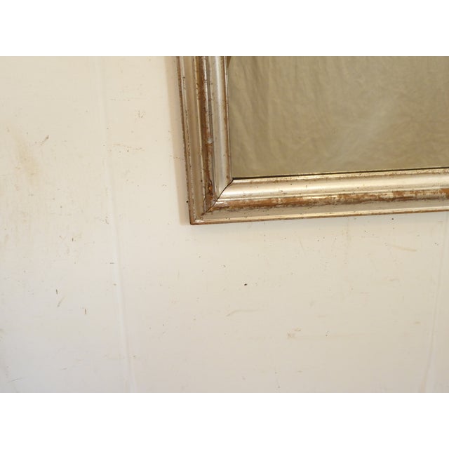 This silverleafed mirror has an old rubbed patina and measures 31.75"H x 20.5"W.