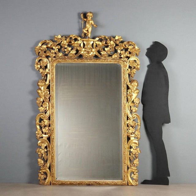 Large Baroque-style mirror, crafted in Italy in the 19th century, featuring an imposing structure in carved and gilded...