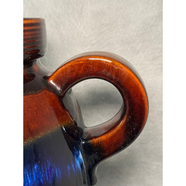 Handled ceramic jug with a cylindrical body, finished in banded glaze in brown and deep cobalt tones.
