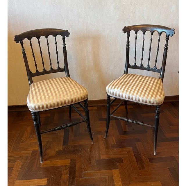 A handsome pair of hand carved, mid-Victorian side chairs in ebonized wood with original period striped upholstery and...