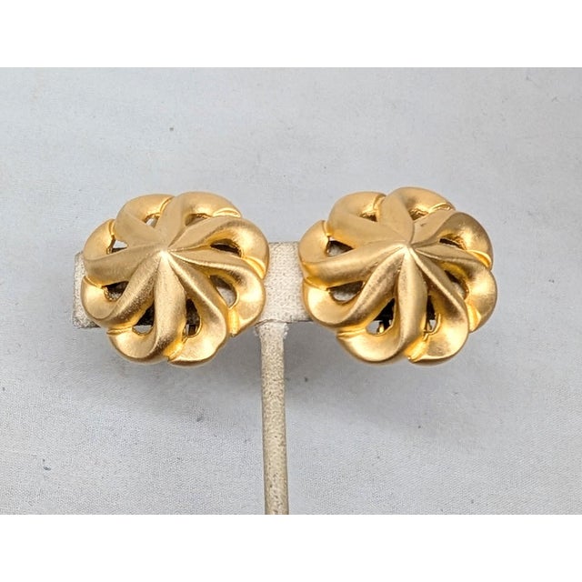 1980s matte goldtone round spiral with pointed center clip earrings. Marked "V©" on the back of one earring, a mark seen...