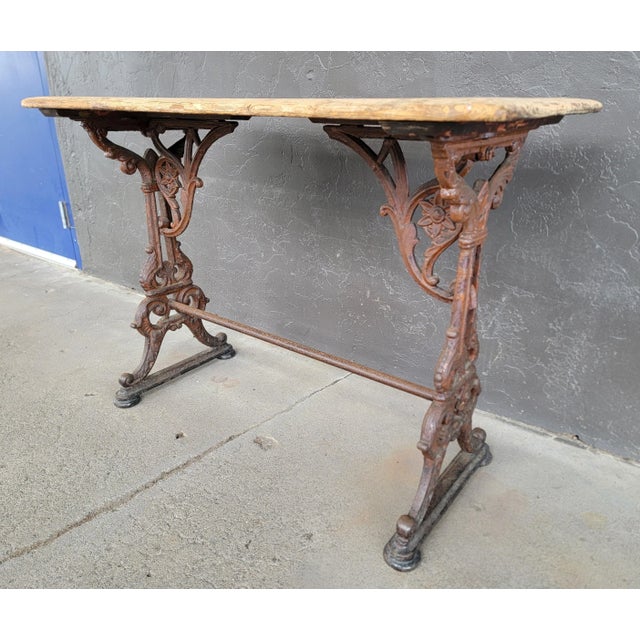 Uncommon rectangular form cast iron pub table. Circa. early 1900's. Highly detailed casting with original painted wood...