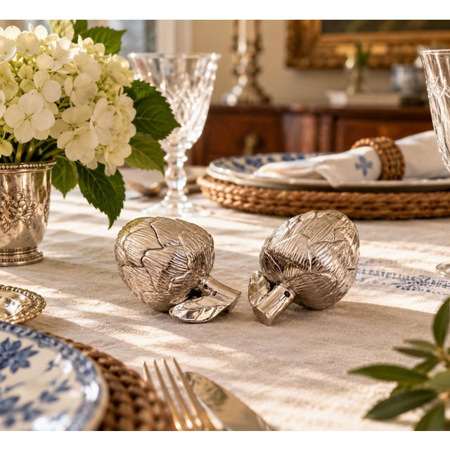 A charming pair of vintage silver-plated artichoke salt and pepper shakers by Godinger, dating to the late 20th century....