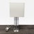 This modern table lamp features a lead crystal base and a simple white rectangular shade. Its clean, minimalist design is...