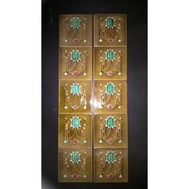 A beautiful set of ten original antique Art Nouveau fireplace tiles, displaying the elegant decorative character and...