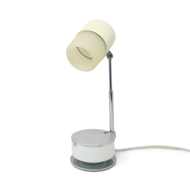 A sleek space-age desk lamp showcasing late 1960s Japanese industrial design at its finest. Crafted from pale cream...