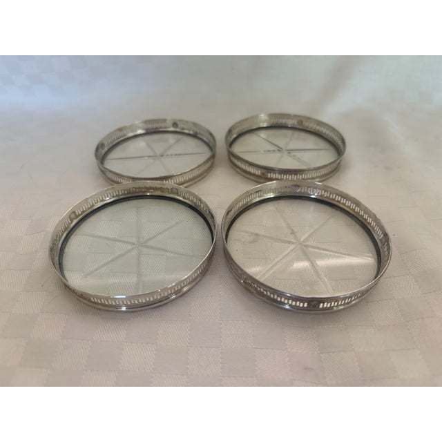 Set of 4 sterling silver rimmed glass coasters. The sterling rims are pierced with a unique pattern and the bottom of each...