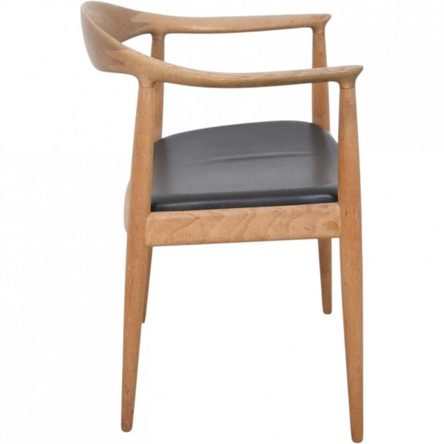 Hans wegner the chair, model jh503, with a frame of oak and a seat upholstered in black leather. The chair is from the...