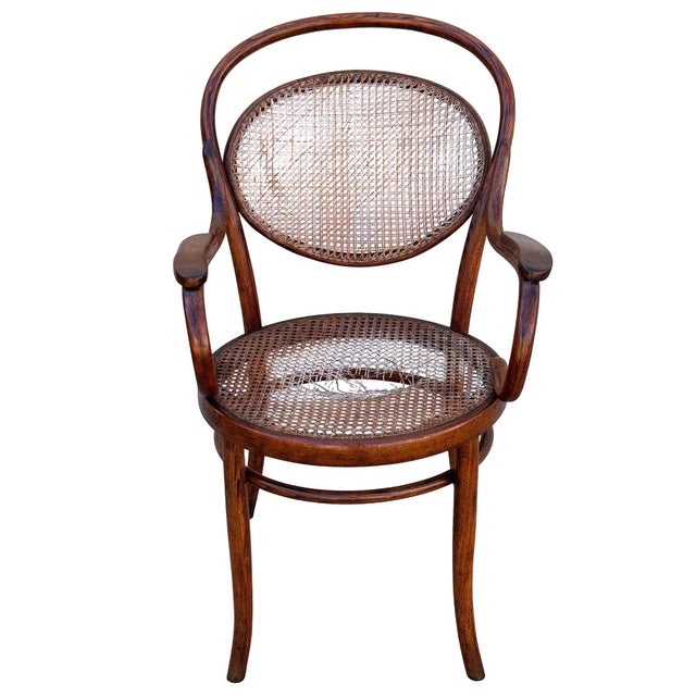 Victorian bent oak & cane number 8256 oak armchair chair by Thonet features an elegant, sculptural frame crafted from...
