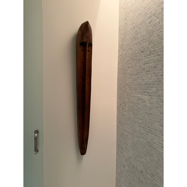 a striking elongated wooden wall sculpture sourced from Material Possessions in Chicagoland, known for their curated mix...