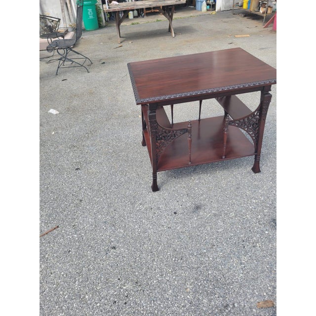 Elegant vintage mahogany two-tier occasional table featuring finely detailed Chippendale-inspired design. The rectangular...