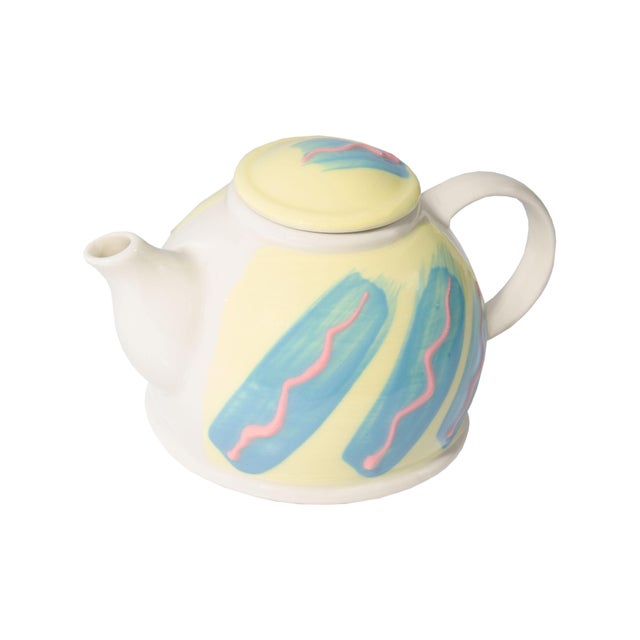 A Postmodern ceramic teapot by Feltman Langer. This teapot has a hand-painted design consisting of a pale yellow...