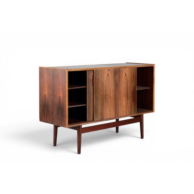 This 1960s Danish sideboard is a study in understated elegance, with a long low silhouette in book-matched rosewood and a...