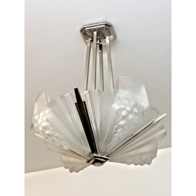 A French Art Deco chandelier by the French artist " Atelier Petitot " in excellent condition. Shades are in clear frosted...