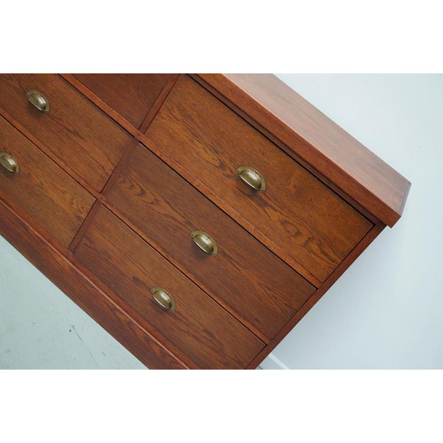 This cabinet was produced during the 1930s in the Netherlands. It features 12 large functional drawers in oak with brass...