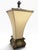 A striking vintage table lamp with an ornate neoclassical-inspired design and warm antique gold-tone finish. The...